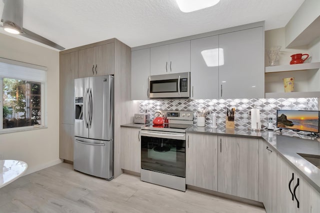 5876 Regal Glen Dr Unit 103, Boynton Beach, FL 33437 - kitchen with stainless steel appliances, backsplash, light wood-type flooring, and modern cabinets