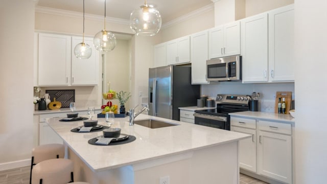 1169 SE Crosswood Way, Port Saint Lucie, FL 34984 - kitchen featuring stainless steel appliances, a sink, ornamental molding, white cabinetry, and a kitchen breakfast bar