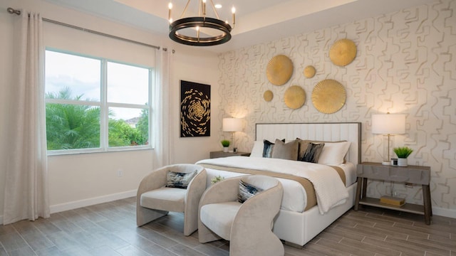 1169 SE Crosswood Way, Port Saint Lucie, FL 34984 - bedroom featuring baseboards, wallpapered walls, an accent wall, a chandelier, and wood tiled floors