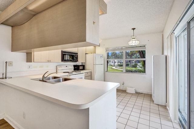 8155 Chelsea Ct Unit 55A, West Palm Beach, FL 33406 - kitchen featuring white appliances, a sink, light countertops, a peninsula, and a textured ceiling