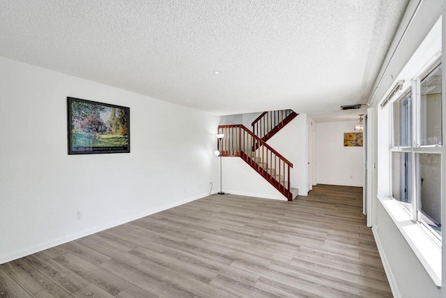 8155 Chelsea Ct Unit 55A, West Palm Beach, FL 33406 - unfurnished living room with stairway, light wood finished floors, a textured ceiling, and baseboards