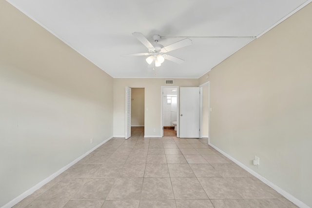 719 Lori Dr Unit 102, Palm Springs, FL 33461 - unfurnished bedroom featuring light tile patterned flooring, baseboards, ceiling fan, ensuite bath, and a spacious closet