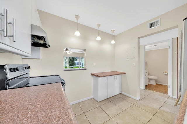 719 Lori Dr Unit 102, Palm Springs, FL 33461 - kitchen with stainless steel electric range, exhaust hood, white cabinets, light tile patterned floors, and decorative light fixtures