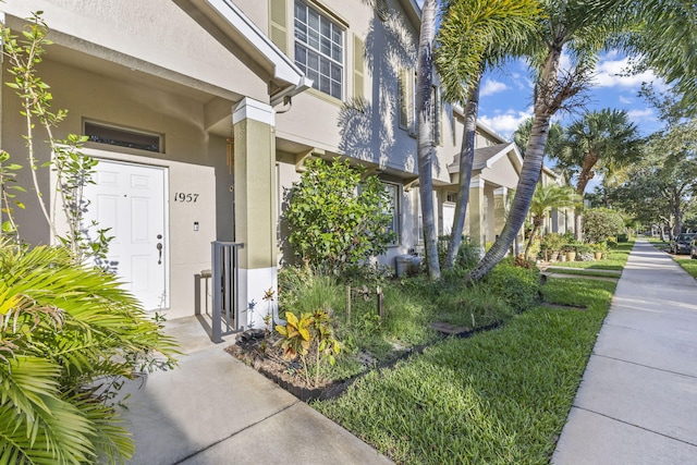 1957 SE Avon Park Dr, Port Saint Lucie, FL 34952 - view of exterior entry featuring stucco siding