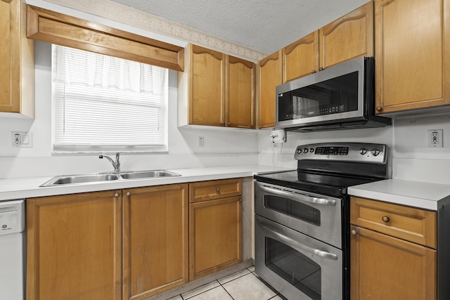 5618 Kingsmill Ct, Greenacres, FL 33463 - kitchen featuring stainless steel appliances, a sink, light countertops, light tile patterned floors, and a textured ceiling