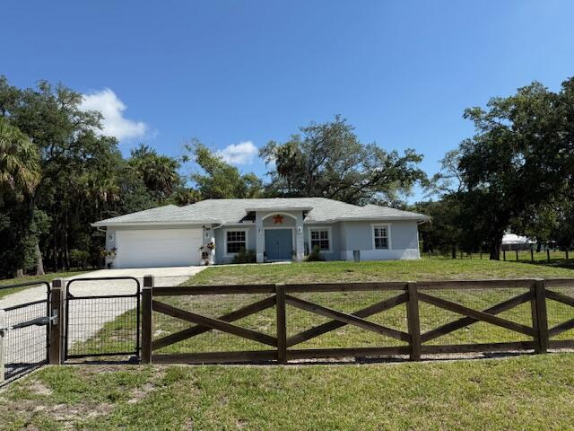15741 97th Rd N, West Palm Beach, FL 33412 - single story home with an attached garage, driveway, and a gate