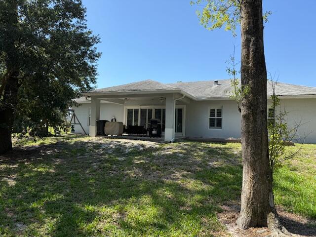 15741 97th Rd N, West Palm Beach, FL 33412 - rear view of house featuring a yard, stucco siding, and a patio
