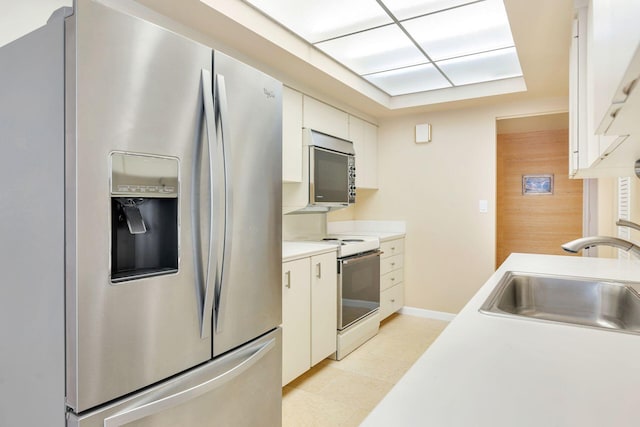 3300 S Ocean Blvd Unit 101S, Palm Beach, FL 33480 - kitchen with appliances with stainless steel finishes, a sink, light countertops, white cabinetry, and baseboards