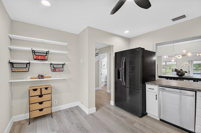 2703 Maplewood Dr, Greenacres, FL 33415 - kitchen featuring stainless steel dishwasher, black fridge, light wood-type flooring, ceiling fan, and white cabinetry