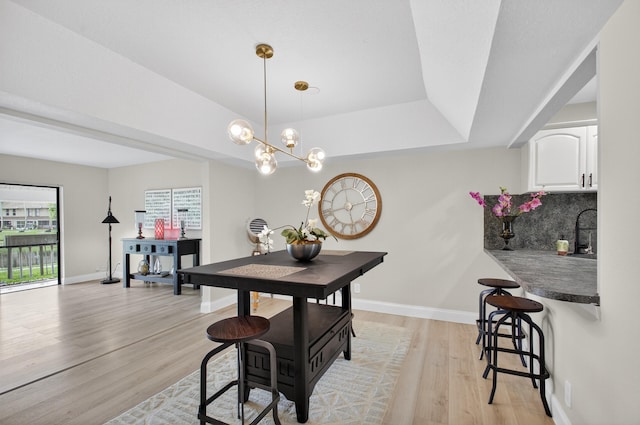2703 Maplewood Dr, Greenacres, FL 33415 - dining area featuring light wood finished floors, baseboards, a chandelier, and a tray ceiling