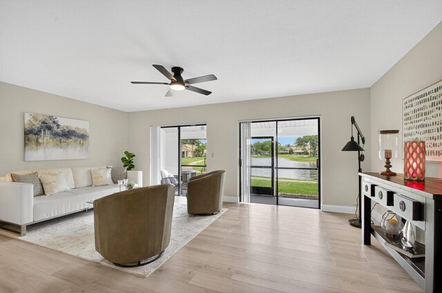 2703 Maplewood Dr, Greenacres, FL 33415 - living area with ceiling fan, light wood-type flooring, a water view, and baseboards