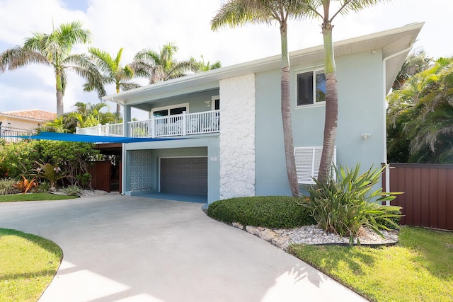 1809 Surfside Dr, Fort Pierce, FL 34949 - view of front facade featuring a balcony, concrete driveway, an attached garage, and stucco siding