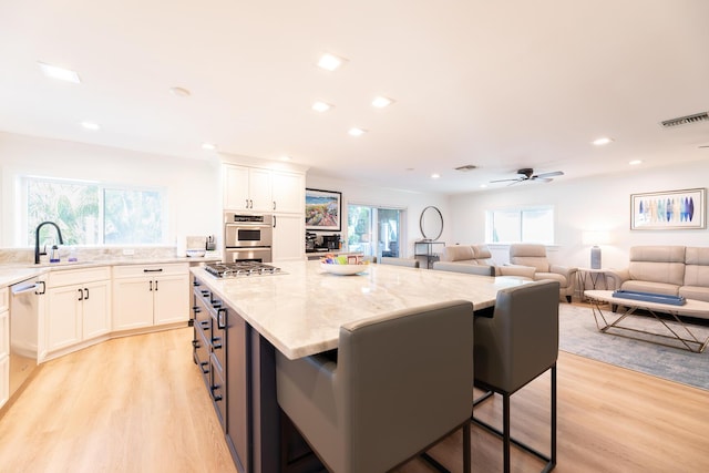 1809 Surfside Dr, Fort Pierce, FL 34949 - kitchen featuring a sink, light stone countertops, light wood-style floors, white cabinets, and recessed lighting