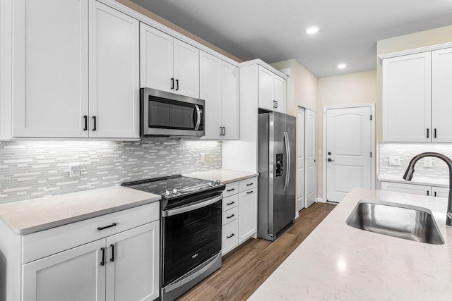 4858 Blistering Way, Lake Worth, FL 33467 - kitchen with stainless steel appliances, a sink, dark wood finished floors, white cabinets, and recessed lighting