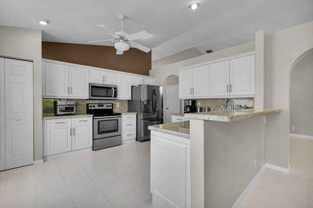 6563 Kings Creek Ter, Boynton Beach, FL 33437 - kitchen featuring appliances with stainless steel finishes, arched walkways, backsplash, ceiling fan, and high vaulted ceiling
