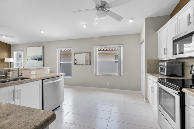 6563 Kings Creek Ter, Boynton Beach, FL 33437 - kitchen featuring stainless steel appliances, a sink, baseboards, white cabinetry, and recessed lighting