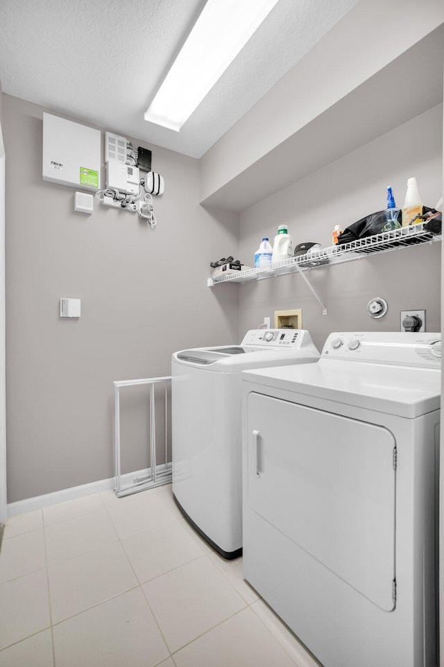 6563 Kings Creek Ter, Boynton Beach, FL 33437 - washroom featuring washing machine and dryer, baseboards, a textured ceiling, and light tile patterned floors
