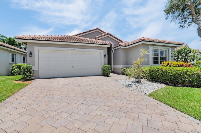 6563 Kings Creek Ter, Boynton Beach, FL 33437 - mediterranean / spanish home with stucco siding, decorative driveway, an attached garage, and a tile roof