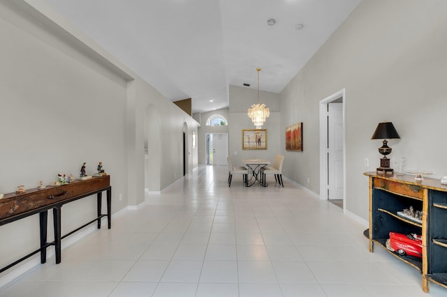 6563 Kings Creek Ter, Boynton Beach, FL 33437 - hallway featuring a chandelier, light tile patterned flooring, high vaulted ceiling, and baseboards