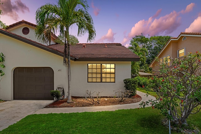 453 NE 38th St, Boca Raton, FL 33431 - view of front of property with a garage, driveway, stucco siding, a tiled roof, and a lawn