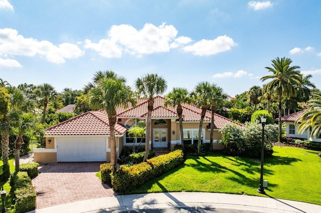 1345 SW 21st Ave, Boca Raton, FL 33486 - mediterranean / spanish house with stucco siding, french doors, an attached garage, a front yard, and driveway