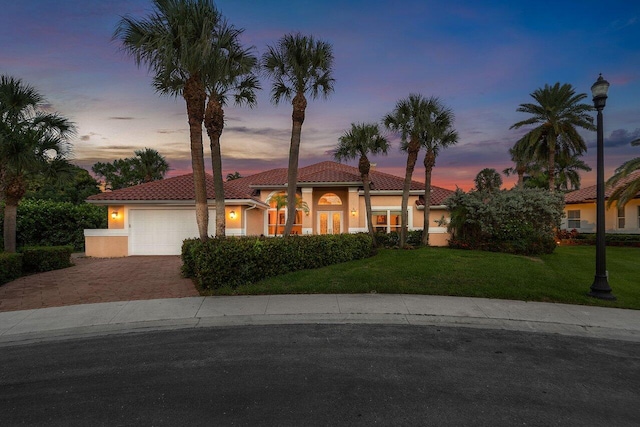 1345 SW 21st Ave, Boca Raton, FL 33486 - mediterranean / spanish home featuring decorative driveway, a tiled roof, a yard, stucco siding, and a garage