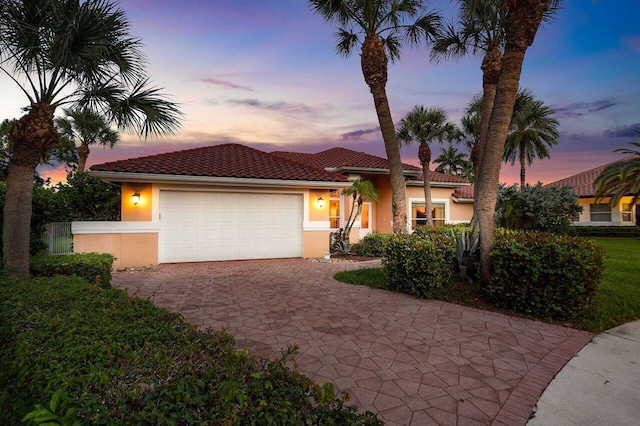 1345 SW 21st Ave, Boca Raton, FL 33486 - mediterranean / spanish house featuring stucco siding, decorative driveway, an attached garage, and a tile roof