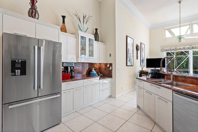 1345 SW 21st Ave, Boca Raton, FL 33486 - kitchen featuring stainless steel appliances, a sink, crown molding, dark countertops, and white cabinetry