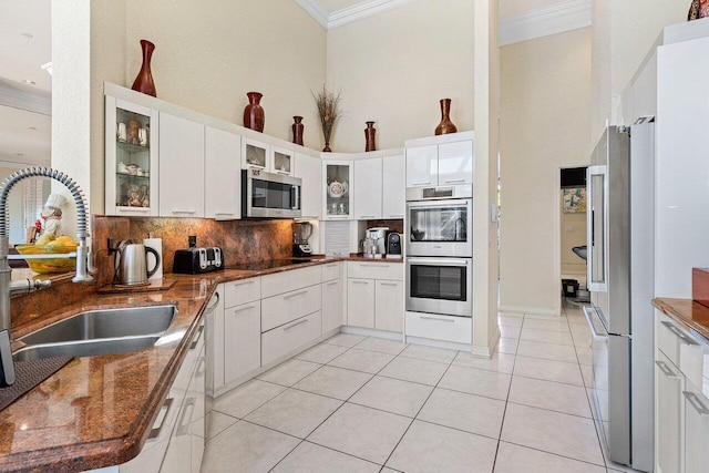 1345 SW 21st Ave, Boca Raton, FL 33486 - kitchen featuring crown molding, appliances with stainless steel finishes, a sink, backsplash, and light tile patterned flooring