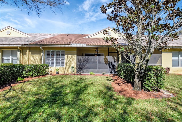 9308 Swansea Ln, West Palm Beach, FL 33411 - back of house featuring a yard, a tiled roof, and stucco siding