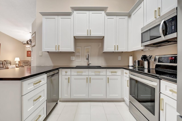 9308 Swansea Ln, West Palm Beach, FL 33411 - kitchen with appliances with stainless steel finishes, a sink, light tile patterned flooring, a peninsula, and dark countertops