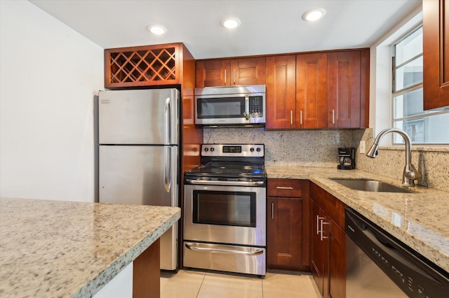 1040 SE 4th Ave Unit 129, Deerfield Beach, FL 33441 - kitchen with stainless steel appliances, tasteful backsplash, light stone counters, recessed lighting, and light tile patterned floors
