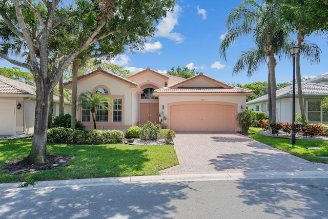 7585 Las Cruces Ct, Boynton Beach, FL 33437 - mediterranean / spanish-style home with stucco siding, a garage, driveway, a front yard, and a tile roof