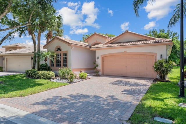 7585 Las Cruces Ct, Boynton Beach, FL 33437 - mediterranean / spanish home featuring an attached garage, stucco siding, a front yard, and decorative driveway