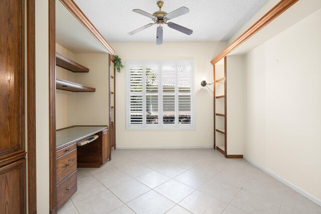 7585 Las Cruces Ct, Boynton Beach, FL 33437 - unfurnished office featuring a ceiling fan, built in study area, a textured ceiling, baseboards, and light tile patterned floors