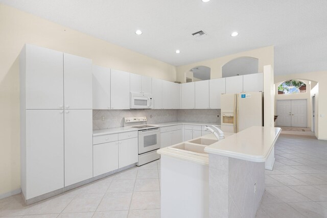 7585 Las Cruces Ct, Boynton Beach, FL 33437 - kitchen featuring white appliances, a sink, light tile patterned floors, a center island with sink, and backsplash