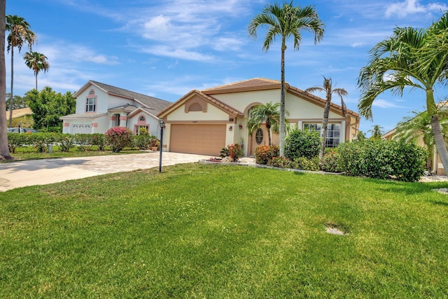 12697 Coral Breeze Dr, Wellington, FL 33414 - mediterranean / spanish house featuring stucco siding, driveway, a garage, and a front lawn