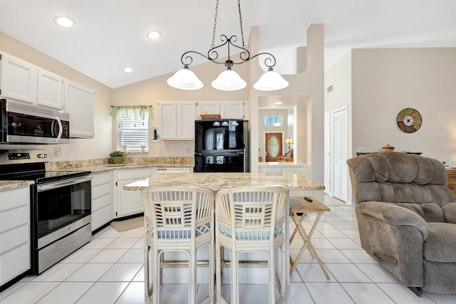 12697 Coral Breeze Dr, Wellington, FL 33414 - kitchen with appliances with stainless steel finishes, open floor plan, a sink, a breakfast bar area, and white cabinets
