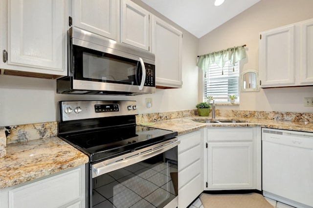 12697 Coral Breeze Dr, Wellington, FL 33414 - kitchen with stainless steel appliances, a sink, vaulted ceiling, white cabinets, and light tile patterned flooring