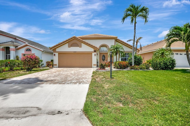 12697 Coral Breeze Dr, Wellington, FL 33414 - mediterranean / spanish house with driveway, an attached garage, a front lawn, stucco siding, and a tile roof