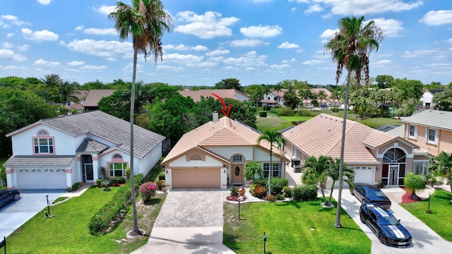 12697 Coral Breeze Dr, Wellington, FL 33414 - view of front facade with driveway, stucco siding, a residential view, and a front lawn