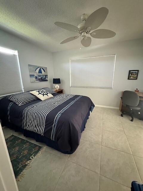 1120 Mahogany Way Unit 204, Delray Beach, FL 33445 - bedroom featuring tile patterned floors, a textured ceiling, ceiling fan, and baseboards