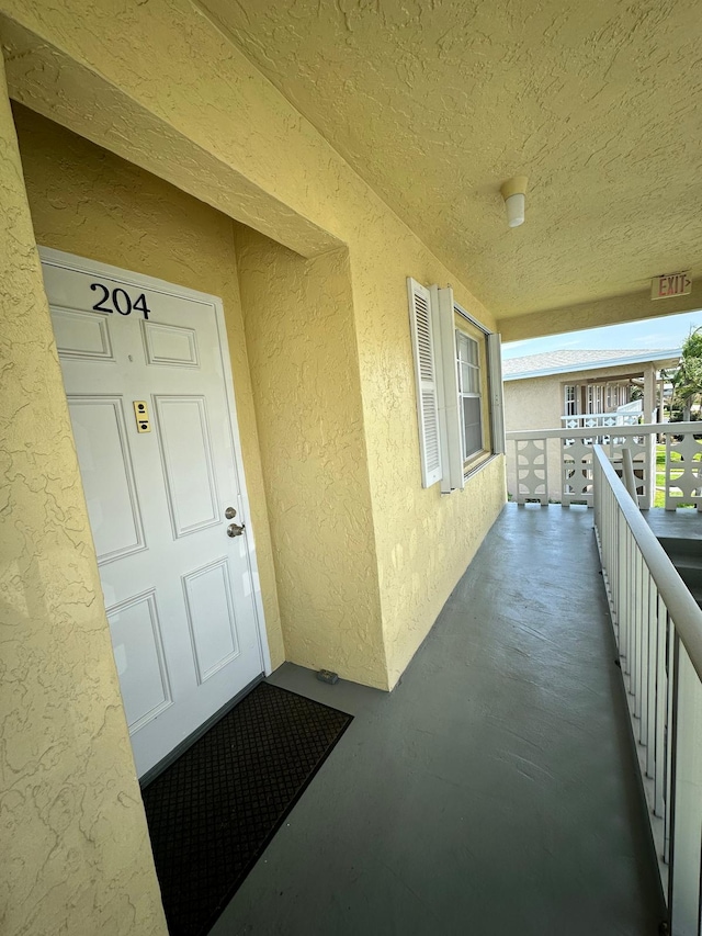 1120 Mahogany Way Unit 204, Delray Beach, FL 33445 - property entrance with stucco siding and a balcony
