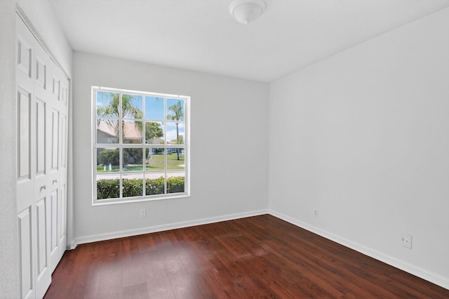 9329 Boca Gardens Cir S Unit D, Boca Raton, FL 33496 - unfurnished bedroom featuring dark wood-style flooring and a closet