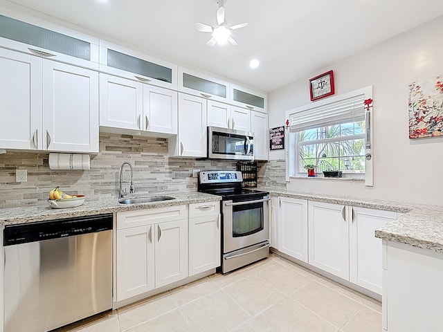 3622 Citrus Trce Unit 2, Davie, FL 33328 - kitchen with appliances with stainless steel finishes, a sink, decorative backsplash, a ceiling fan, and light tile patterned floors