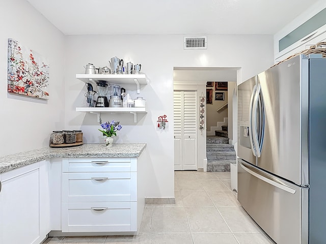 3622 Citrus Trce Unit 2, Davie, FL 33328 - kitchen with stainless steel fridge with ice dispenser, light tile patterned flooring, light stone counters, and white cabinets