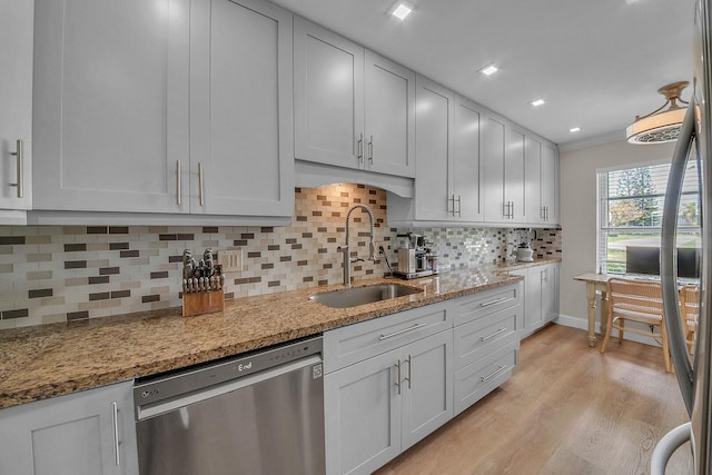 1140 Mahogany Way Unit 103, Delray Beach, FL 33445 - kitchen featuring a sink, stainless steel dishwasher, light wood-style floors, backsplash, and light stone countertops