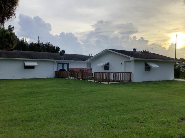 1210 Hartman Rd, Fort Pierce, FL 34947 - back of property featuring a yard and stucco siding