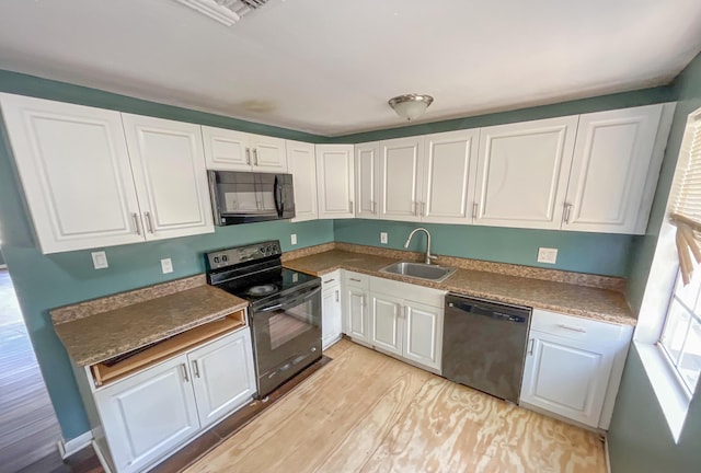 2818 Alabama St, West Palm Beach, FL 33406 - kitchen featuring black appliances, a sink, white cabinetry, and light wood-type flooring