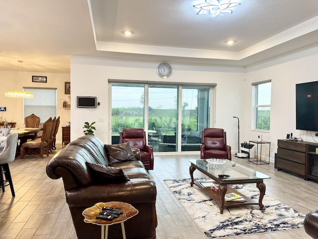 1130 Tangled Orchard Trce, The Acreage, FL 33470 - living area featuring a tray ceiling, light wood-style flooring, and a chandelier
